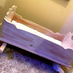 Vintage handmade baby cradle with heart accents.
